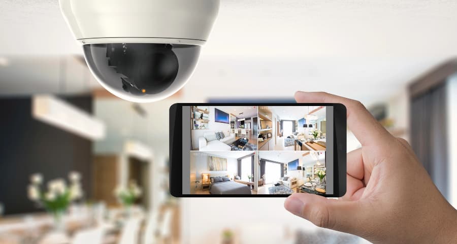 Homeowner holding smartphone with video feed from security cameras in Tempe